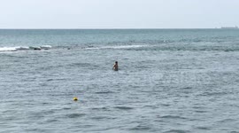A tourist bathes in the sea at Lido di Ostia on a warm March day in Rome.