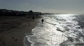 A metal prospector, against the light, searches for precious objects along the beach of Lido di Ostia on a beautiful March day in Rome.