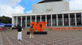 Tourists take souvenir photos with the large number 30 that was installed at the Expo Village of the Rome Marathon (Run Rome The Marathon) under construction at the Palazzo dei Congressi in Rome.