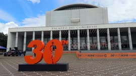 Tourists take souvenir photos with the large number 30 that was installed at the Expo Village of the Rome Marathon (Run Rome The Marathon) under construction at the Palazzo dei Congressi in Rome.