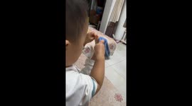 Frustrated child hits leg while struggling with sock in Shaanxi, China