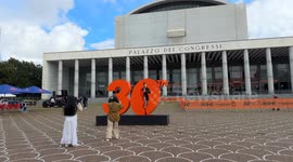 Tourists take souvenir photos with the large number 30 that was installed at the Expo Village of the Rome Marathon (Run Rome The Marathon) under construction at the Palazzo dei Congressi in Rome.
