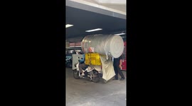 Motorcycle rider carries huge water tank on the back of bike