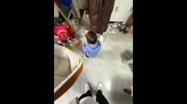 Baby adorably tries to remove hat on his head