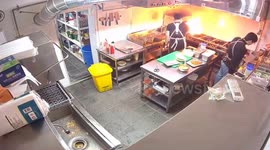 Calm kitchen staff extinguish pan fire while others panic