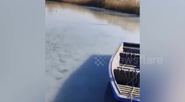 Brave rescuer frees swan trapped on icy lake in China
