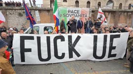 Some protesters hold up a large banner with the slogan 'fuck EU' while MARCO RIZZO speaks on the stage which bears the slogan 'peace and sovereignty' and where FRANCESCO TOSCANO (CR) is also present during the demonstration entitled ‘Peace and sovereignty