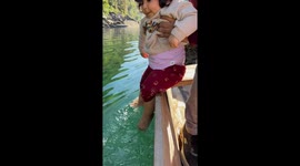 Toddler enjoys playing in Umngot River while on boat in Meghalaya, India