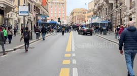 Two police vans cordon off the square and an unmarked police car with its flashing lights enters the crowd in Piazza Barberini during the demonstration to say no to rearmament  called by left wing movements in Rome.
