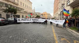 Protesters hold up a large banner with the slogan 'the Russian people are not my enemy' during the demonstration to say no to rearmament called by left wing movements in Rome.