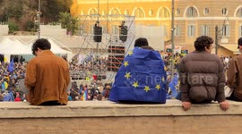 People sitting on the perimeter wall of Piazza del Popolo, one with the European flag on his back, watch from above the demonstration ‘A Square for Europe’ promoted by the journalist Michele Serra in Rome.