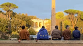 People sitting on the perimeter wall of Piazza del Popolo, one with the European flag on his back, watch from above the demonstration ‘A Square for Europe’ promoted by the journalist Michele Serra in Rome.