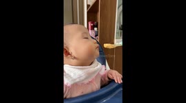 Baby boy still eats porridge despite being barely able to keep eyes open