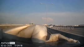 Loose tarpaulin blows into oncoming car on motorway