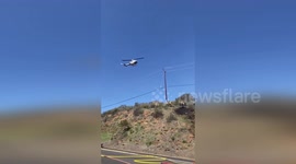 Helicopter dumps water on remnants of Sycamore Fire in California