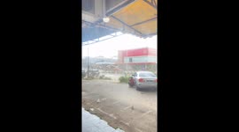 Sudden gusts whip up trash as they tear through car park