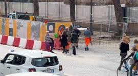 Workers at a Jubilee construction site on Via di San Gregorio between the Colosseum and the Circus Maximus during a break before the Non Una di meno procession passes by on Women's Day in Rome.