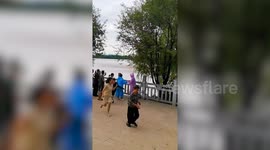 Massive tidal surge sweeps over riverbank - knocking over tourists
