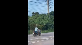 Motorcycle rider balances beer bottle on head