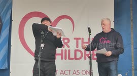Speaker show the picture of the perpetrator rally at the Patriots Of Britain - We march for the children in London, England