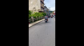 Couple ride with pet dog in motorcycle footwell