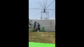 Worker slips off chair while painting school field wall