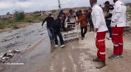 Palestine Red Crescent teams transport a wounded person from the Al-Mughraqa area in central Gaza