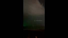 Waterspout tornado tears across horizon as tourists camp in beach