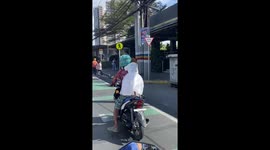 Pet dog in a dress rides on the back of motorcycle