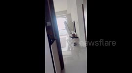 Mum comforts daughter as earthquake shakes over high-rise apartment furniture