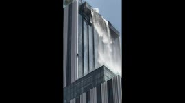 Window cleaner clings to building as earthquake sends water cascading toppling down
