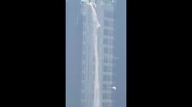 Water cascades down condo building in Bangkok during earthquake