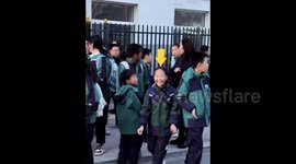 I'm here! Mother clips bright arrow to daughter's head so she can see her easily during pick-up from school