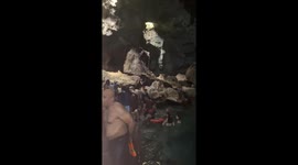 Lady with laptop stands in water during vacation in Hinagdanan Cave