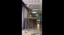 Painter with impressive pony tail tackles office ceiling