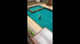 Tourist works out in swimming pool while reading a book