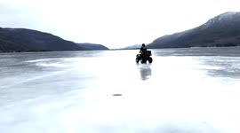Policemen on a quad bike speeds across frozen lake in New York