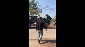 The excavator driver moves the excavator onto the truck with the bucket quickly and professionally