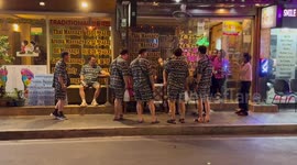 Seven tourists in matching elephant print outfits look for massage