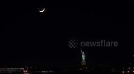 US: Crescent moon descends over Statue of Liberty in New York City