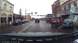 Red SUV nearly backs into driver in a busy stoplight intersection