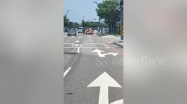 Grandmother rides bike with large cardboard boxes hanging on it