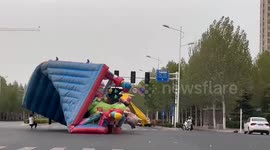 Chaos as children's inflatable castle blown into traffic by strong winds in China