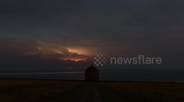 Thunderstorm lights up night's sky above centuries-old temple