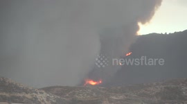 Red-hot fire line under heavy plume full zoom at