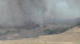 Helicopter firefighting water drop at
