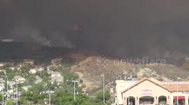 sky crane Helicopter firefighting water drops near houses at