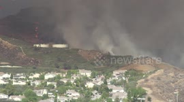 sky crane Helicopter firefighting water drops near houses at