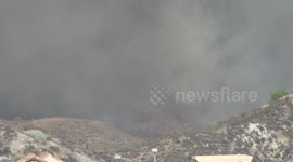 Helicopter water drop in heavy smoke at