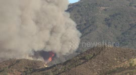Huge flames and fire vortex on mountainside at